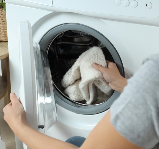 Washing machine with white woolen jumper after being repaired by ZSR Appliance Repairs in Geelong